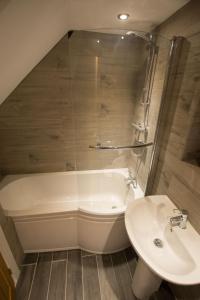 un bagno con vasca, lavandino e WC di Red Rose Cottage a Cockermouth