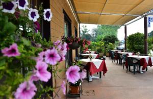 un patio esterno con tavoli, sedie e fiori di Locanda Corte Girlanda a Verona