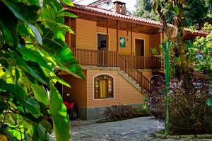 a house with a staircase in front of it at Pousada do Rio Maua in Visconde De Maua