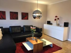 sala de estar con sofá negro y mesa en Ferienwohnung Gipfelnest, en Braunlage