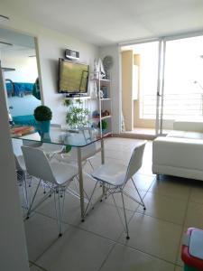 Costa Algarrobo Norte في ألغاروبو: غرفة معيشة مع طاولة وكراسي زجاجية