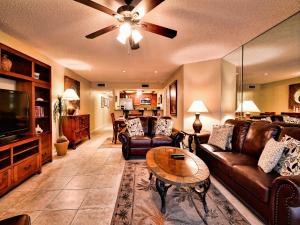 un soggiorno con divani in pelle e TV di Villas of Clearwater Beach 8A a Clearwater Beach