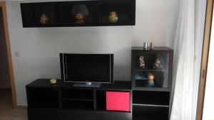a black entertainment center with a television on top of it at Gran apartamento céntrico y muy cerca de la playa in Fuengirola