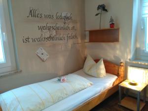 a bedroom with a bed with a sign on the wall at Pension und Restaurant Reck in Aulendorf