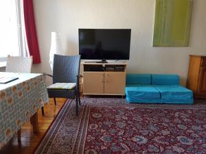 ein Wohnzimmer mit einem TV und einem blauen Sofa in der Unterkunft appartement à Ostende in Ostende