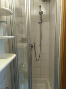 W łazience z przeszklonymi drzwiami znajduje się prysznic. w obiekcie Pension und Restaurant Reck w mieście Aulendorf