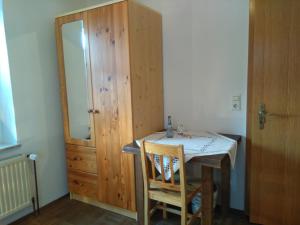 アウレンドルフにあるPension und Restaurant Reckのテーブルと鏡が備わる部屋、木製のキャビネット