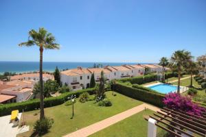 vista su un resort con piscina e palme di Terrazas de Guadalupe J3 a Manilva