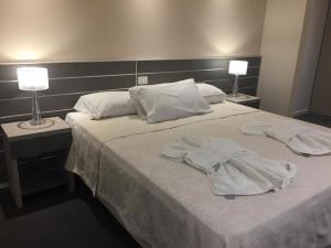 a hotel room with a bed with towels on it at Hotel La Posta in Oncativo