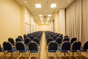 an empty conference room with chairs and curtains at Intercity Suape Costa Dourada in Cabo de Santo Agostinho