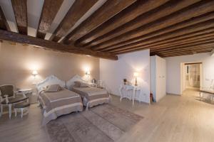 sypialnia z 2 łóżkami i drewnianym sufitem w obiekcie Savoia e jolanda Apartments w Wenecji