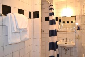 a bathroom with a sink and a shower with towels at Hotel Beez in Maastricht