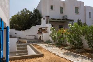 een wit huis met een wastafel in de tuin bij Villa Mariliza in Piso Livadi