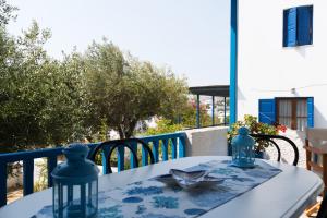 a table with a blue and white table cloth on a balcony at Villa Mariliza in Piso Livadi