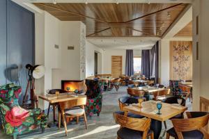 ein Restaurant mit Holztischen und -stühlen und einem Kamin in der Unterkunft Valentyna in Brjuchowytschi