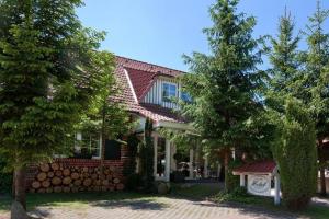 una casa de ladrillo rojo con un árbol delante en Das kleine Hotel am Park Garni, en Bispingen