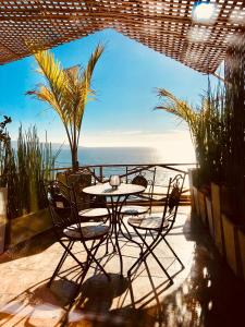 a patio with a table and chairs and the ocean at Pacificsunset Reñaca in Viña del Mar
