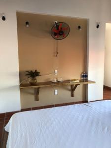 a room with a bed with a shelf and a clock at Phu Quoc Kim 2 Beach Front Resort in Phú Quốc