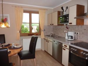 a kitchen with a table and a counter top at Im-Oberland - Tal - KönigsCard in Bad Kohlgrub