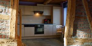 een keuken met witte apparatuur en een bakstenen muur bij Chez Amand in Devantave