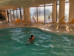 a woman is swimming in a swimming pool at Studio 166 Le Bristol Villars in Villars-sur-Ollon
