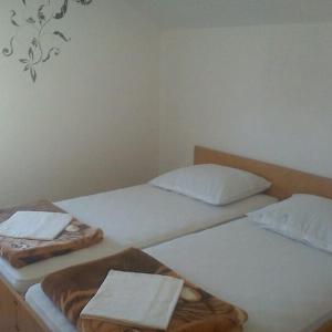 two twin beds in a room with white walls at Apartments Nada in Vir