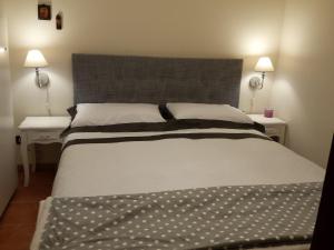 カステル・ディ・サングロにあるAppartamento Golden Parkのベッドルーム1室(大型ベッド1台、ランプ2つ付)