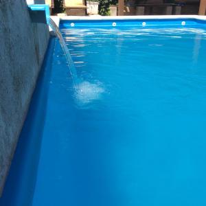 una persona en una piscina con una fuente de agua en Robinson Apartamentos SOLO FAMILIAS en Villa Carlos Paz