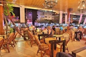 um restaurante com mesas e cadeiras e pessoas sentadas a eles em Gallion Hotel em Alanya