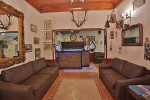 uma sala de estar com sofás de couro e um espelho em Gallion Hotel em Alanya