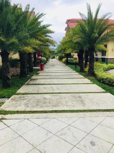 a long sidewalk with palm trees on each side at San Remo Oasis, Citta De Mari in Cebu City