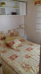 sypialnia z dużym łóżkiem z narzutą kwiatową w obiekcie Camping Lluçanès w mieście Olost