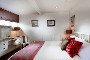 a hotel room with a bed, table, and window at Tufton Arms Hotel in Appleby