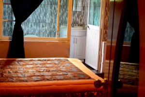 a bed in a room with a window at Hostal Mirador de Otavalo in Otavalo