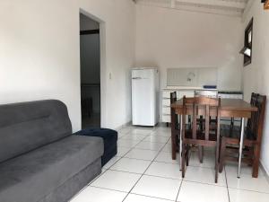a living room with a couch and a table and a kitchen at Pousada Residencial Família Dragone in Bombinhas