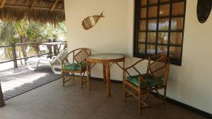 una mesa y dos sillas en un porche en Pousada Entre as Águas, en Imbassai