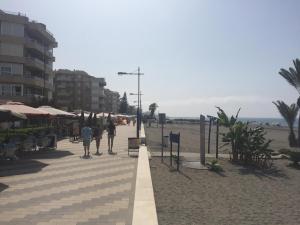 una spiaggia con persone in piedi sulla spiaggia di Apartment Casaluthel Boulevard a Torrox Costa