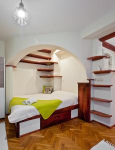 a bedroom with a bed and a spiral staircase at Green Apartment in Budapest