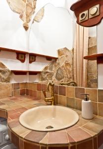 a bathroom with a sink and a stone wall at Green Apartment in Budapest