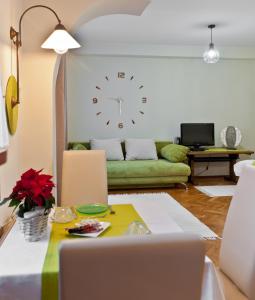 sala de estar con sofá y reloj en la pared en Green Apartment, en Budapest