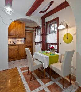 kuchnia i jadalnia ze stołem i krzesłami w obiekcie Green Apartment w Budapeszcie
