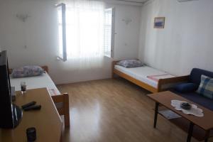 Kleines Zimmer mit 2 Betten und einem Tisch in der Unterkunft Apartman Pavletic in Starigrad