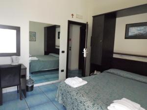 a hotel room with two beds and a cross on the wall at B&B Stella Maris in Diamante