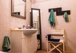 a bathroom with a sink and a mirror and a chair at Casolare Rehva in Cecina