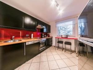 uma cozinha com armários pretos e bancadas vermelhas em Ferienhäuser Schröder em Monschau