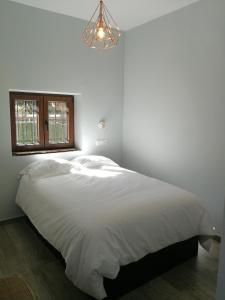 セルセディリャにあるEl Madrigalのシャンデリア付きのベッドルームの白いベッド1台
