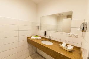 uma casa de banho com um lavatório e um espelho em Mein Palace Hotel em Okriftel