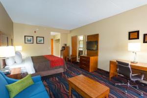 a hotel room with a bed and a desk at Baymont by Wyndham Bonita Springs in Bonita Springs