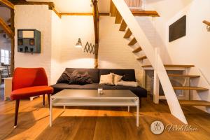 Villa Dohna - Apartment Wedelstam في لايبزيغ: غرفة معيشة مع أريكة ودرج