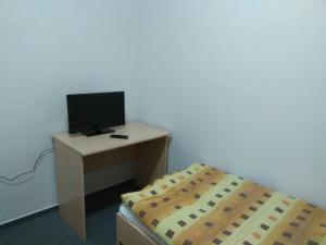 a room with a desk with a computer and a bed at Hotel Lidový dům in Nový Hrozenkov